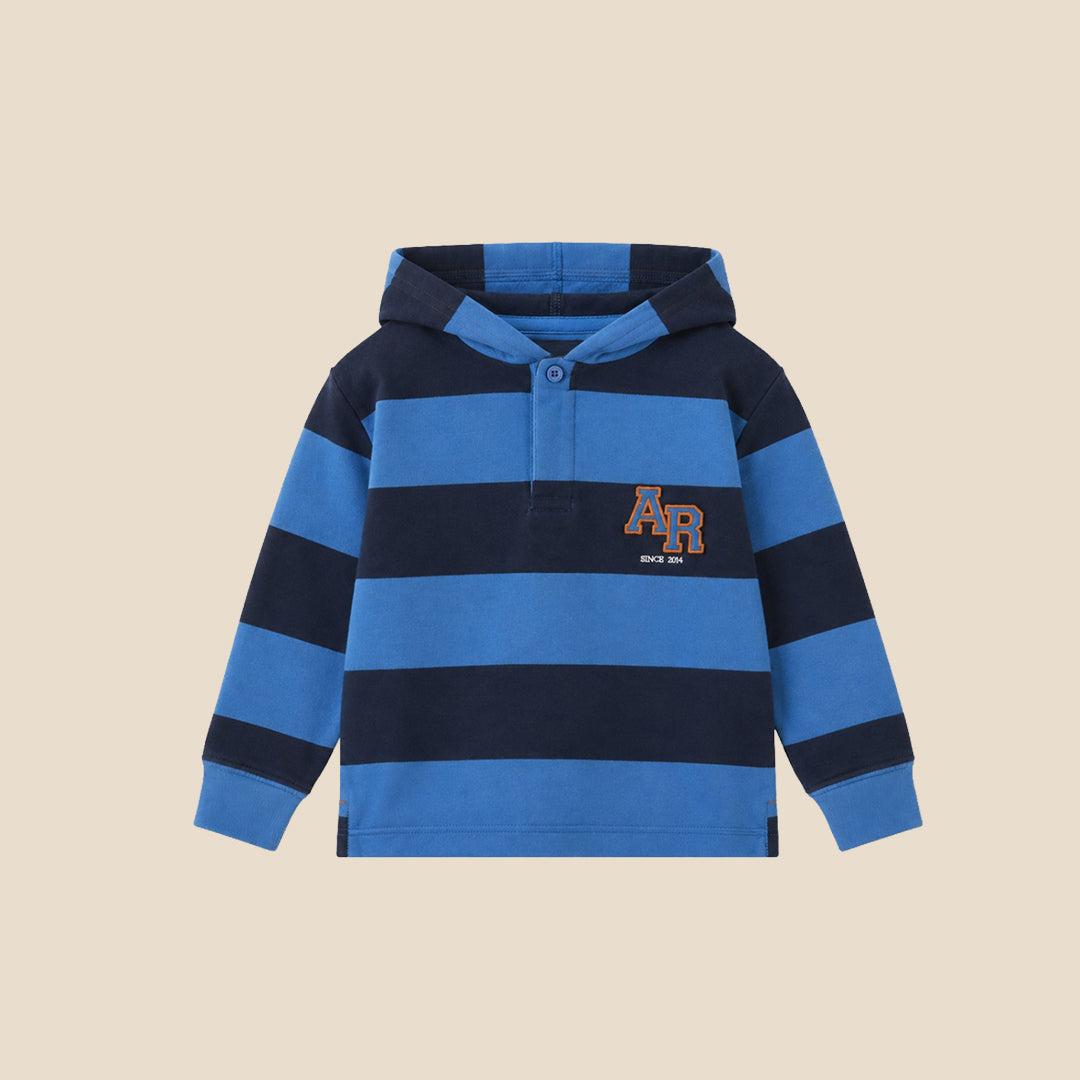 A young boy wearing a blue and navy striped hooded rugby shirt with a 'PFA' logo on the chest, paired with navy cargo pants, set against a solid beige background.